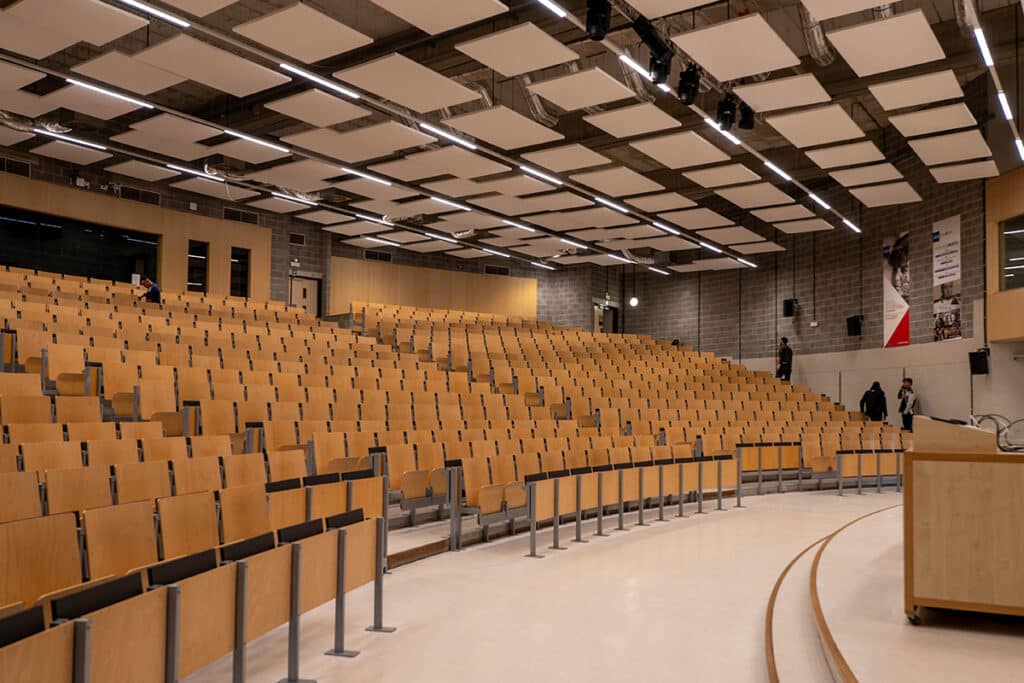 Lege collegezaal met houten stoelen.