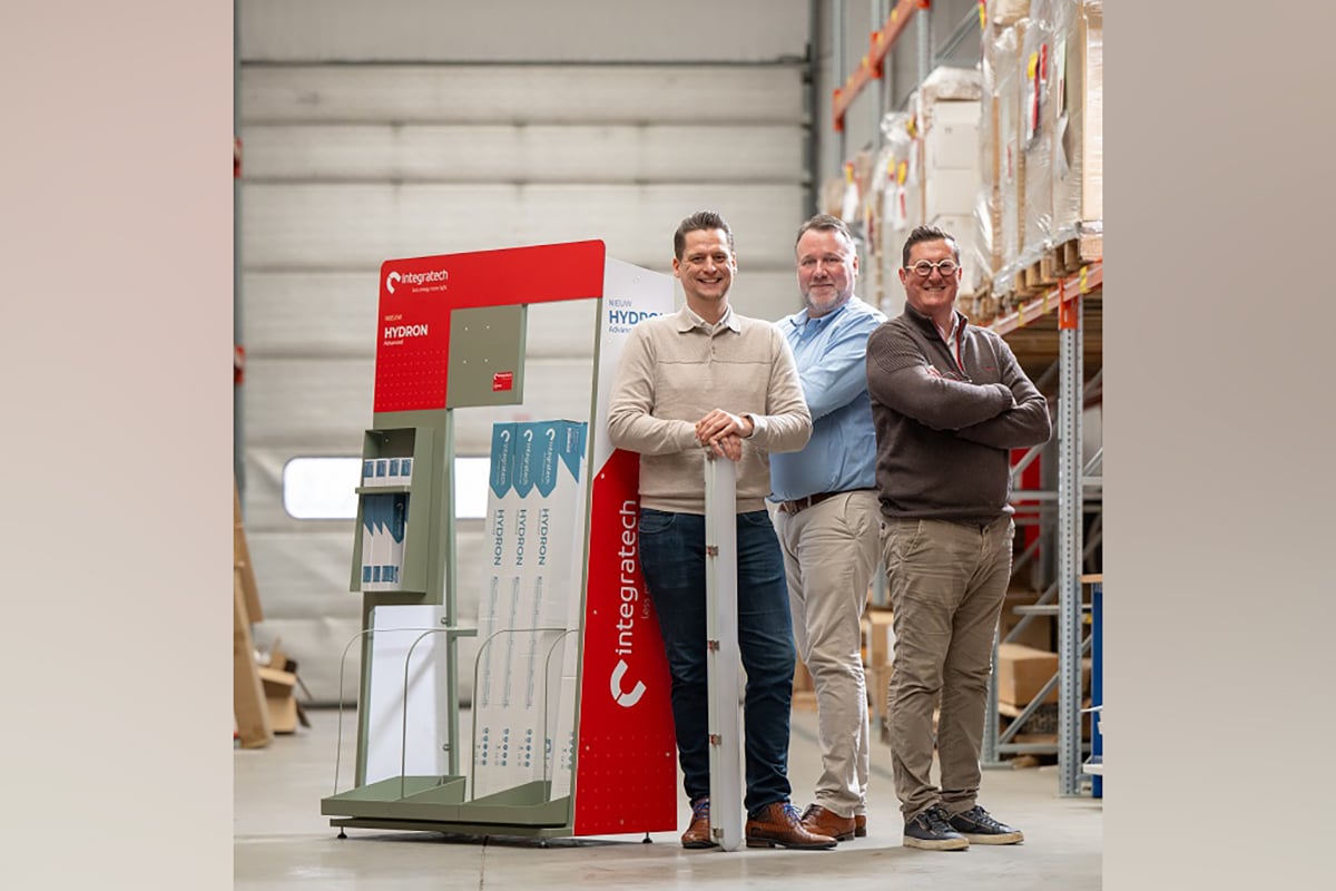 Drie mannen bij een presentatiepaneel.