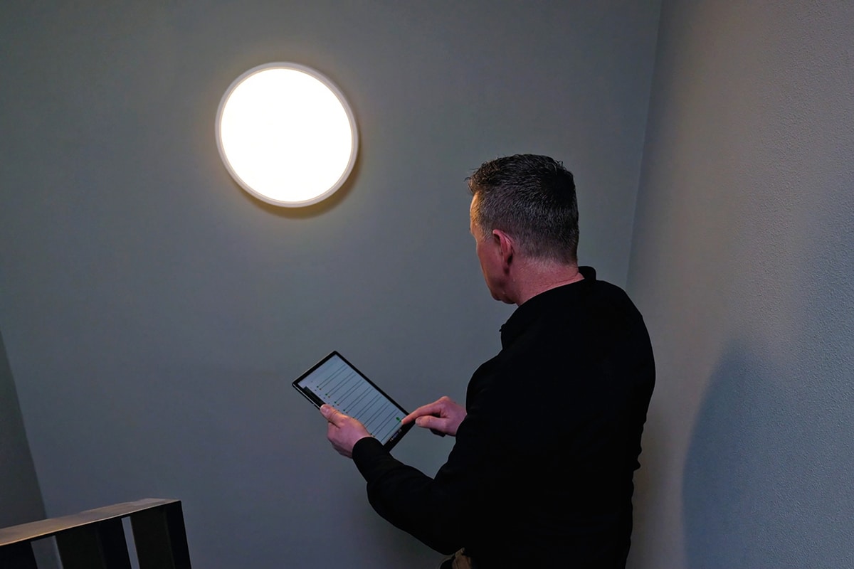 Man met tablet onder plafondlamp